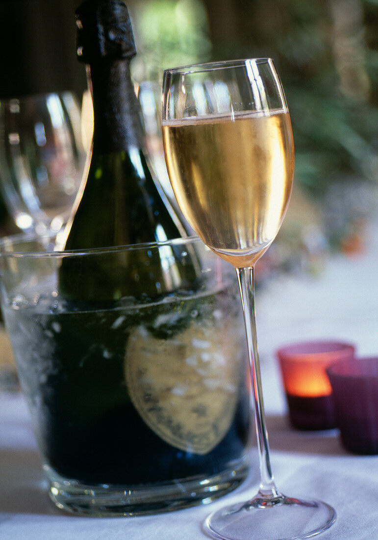 Champagnerflasche im Eiskübel mit Glas Champagner