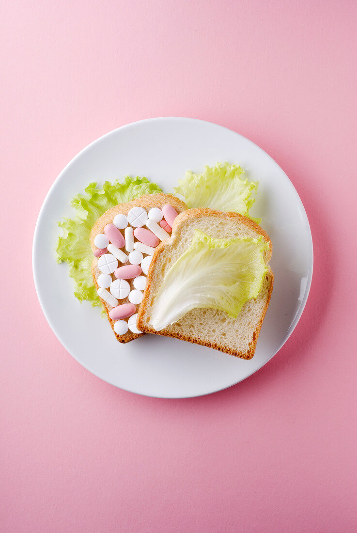 Sandwich mit Tabletten und Salat auf Teller