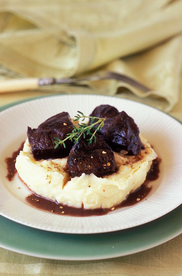 Beef cheeks braised in red wine on mashed potatoes with olive oil