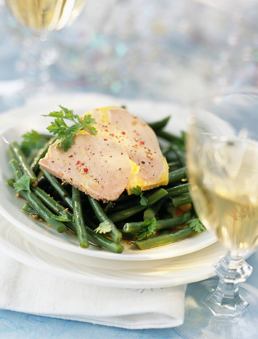 Sliced foie gras on a bed of green beans
