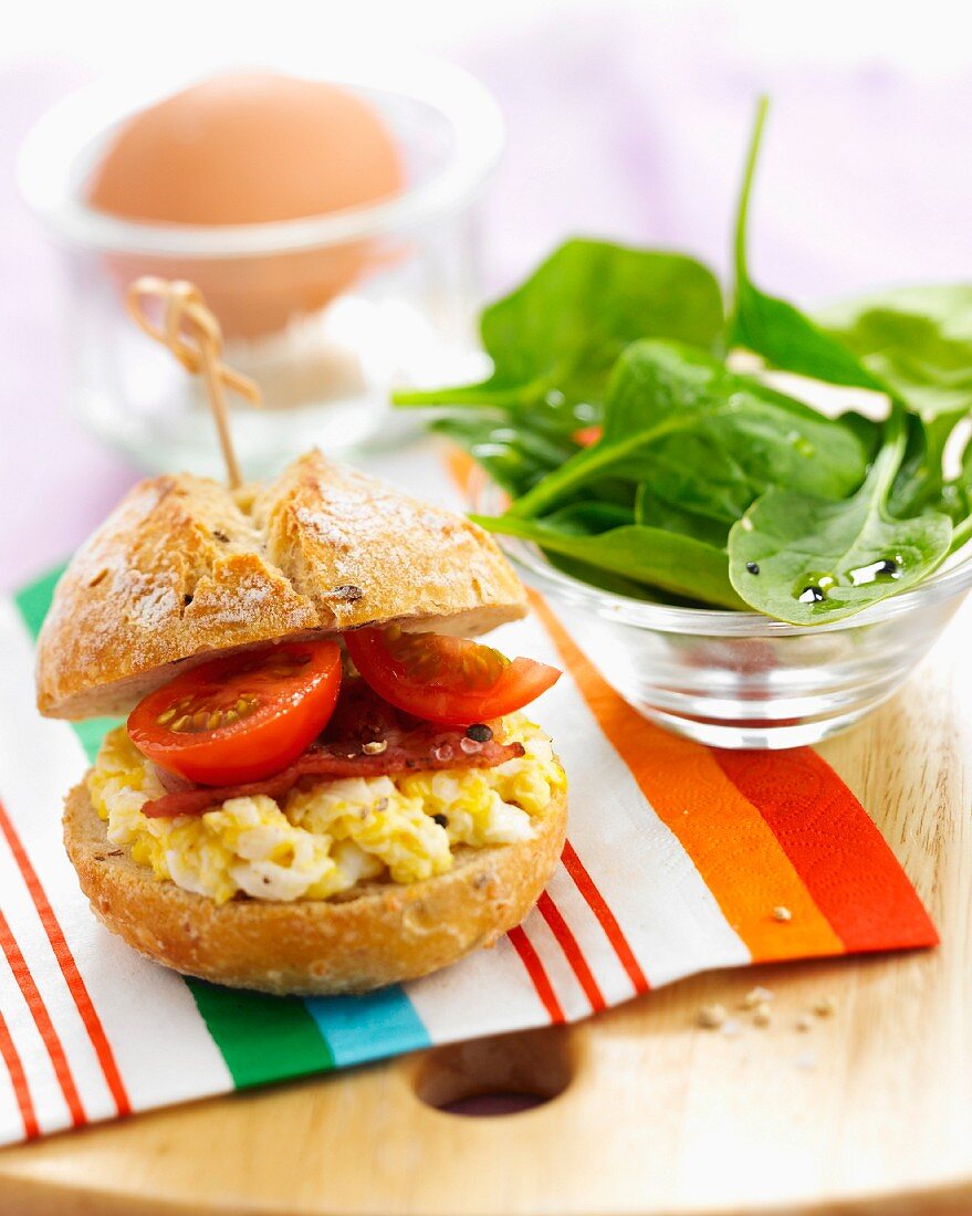 Small scrambled egg, tomato, bacon and spinach shoot salad sandwich