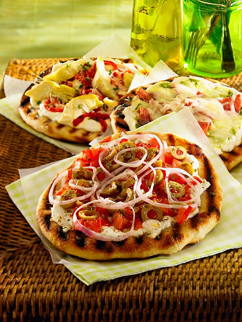 Pizza mit grünen Oliven, Tomaten, roten Zwiebeln und Mozzarella