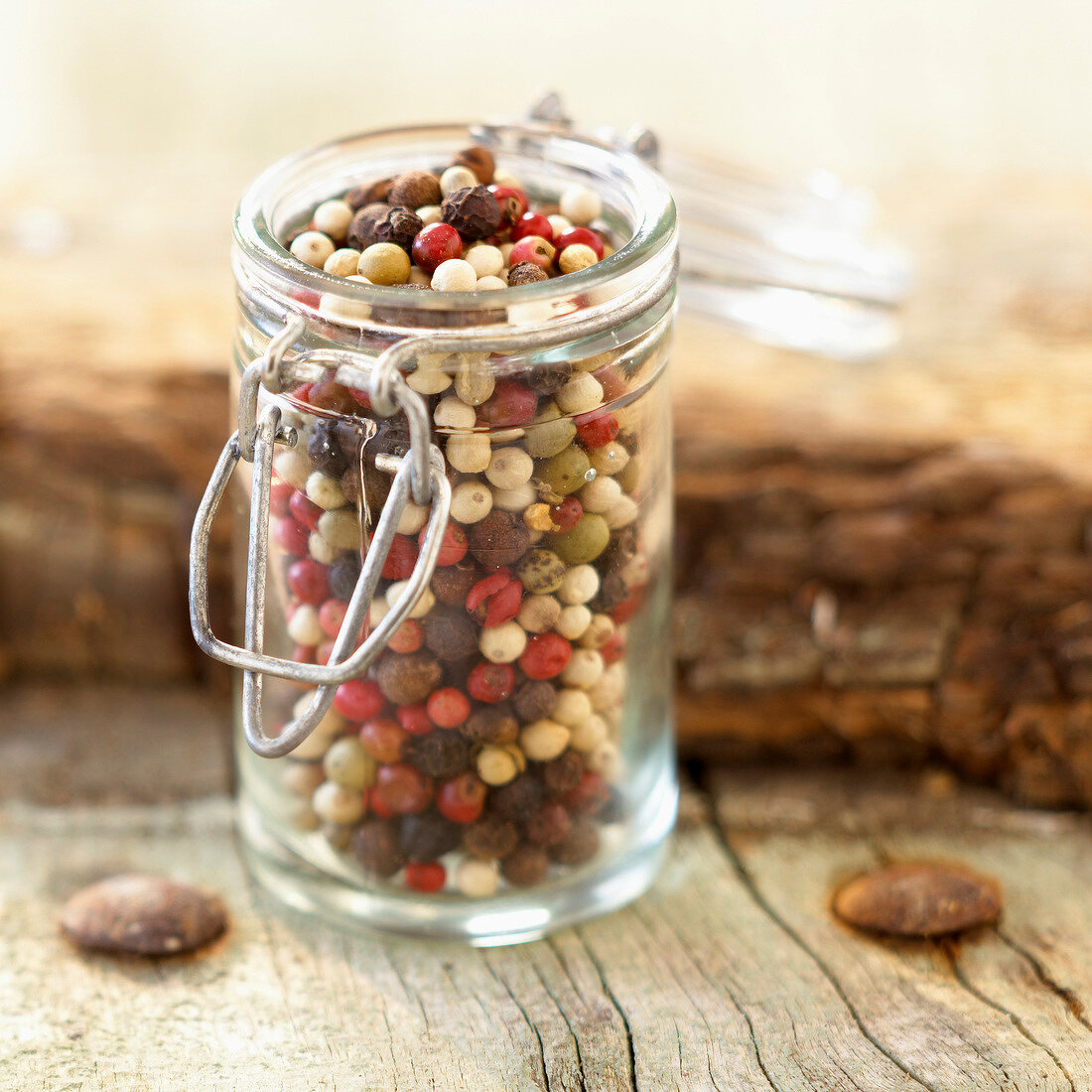Small glass jar of mixed peppercorns and berries