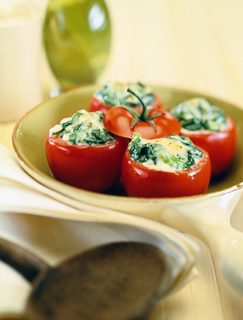 Mit Spinat und Buttersauce gefüllte Tomaten