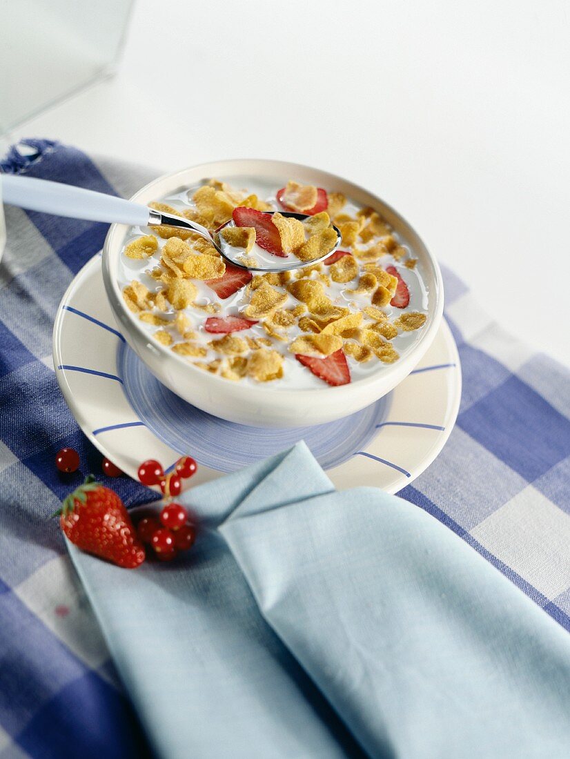 A bowl of cornflakes with strawberries