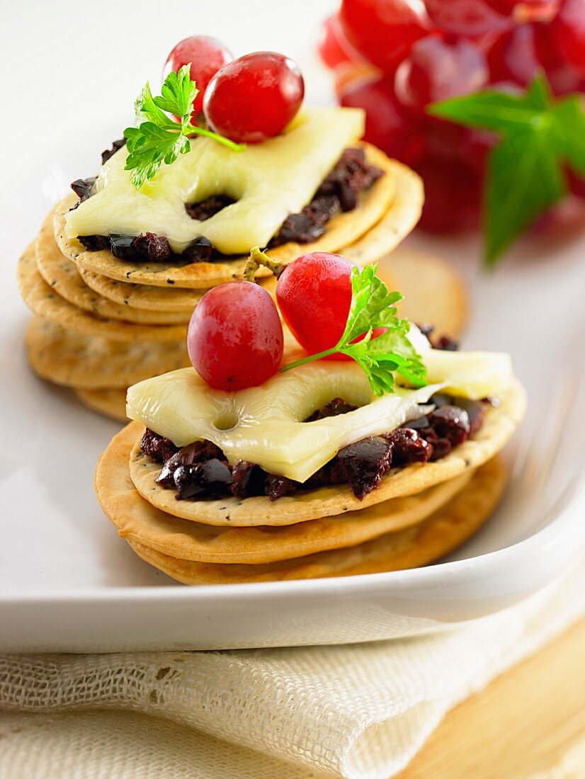 Crackers with cheese, red grapes and black olives