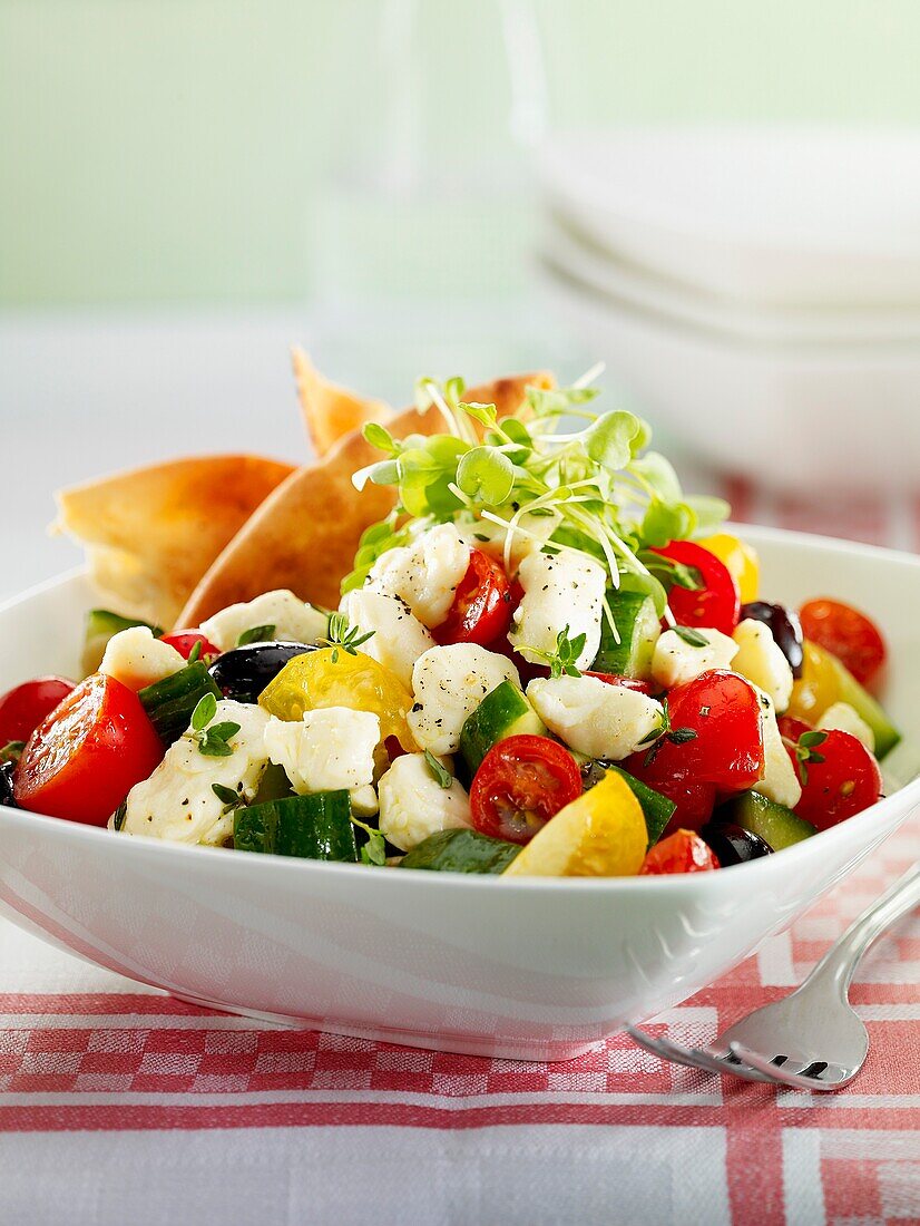 Greek salad with feta cheese and red and yellow tomatoes