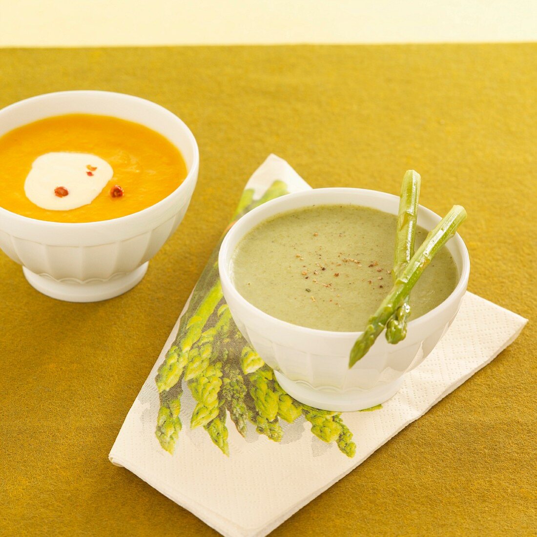 Green cream of asparagus soup, and cream of sweet potato soup with pink pepper