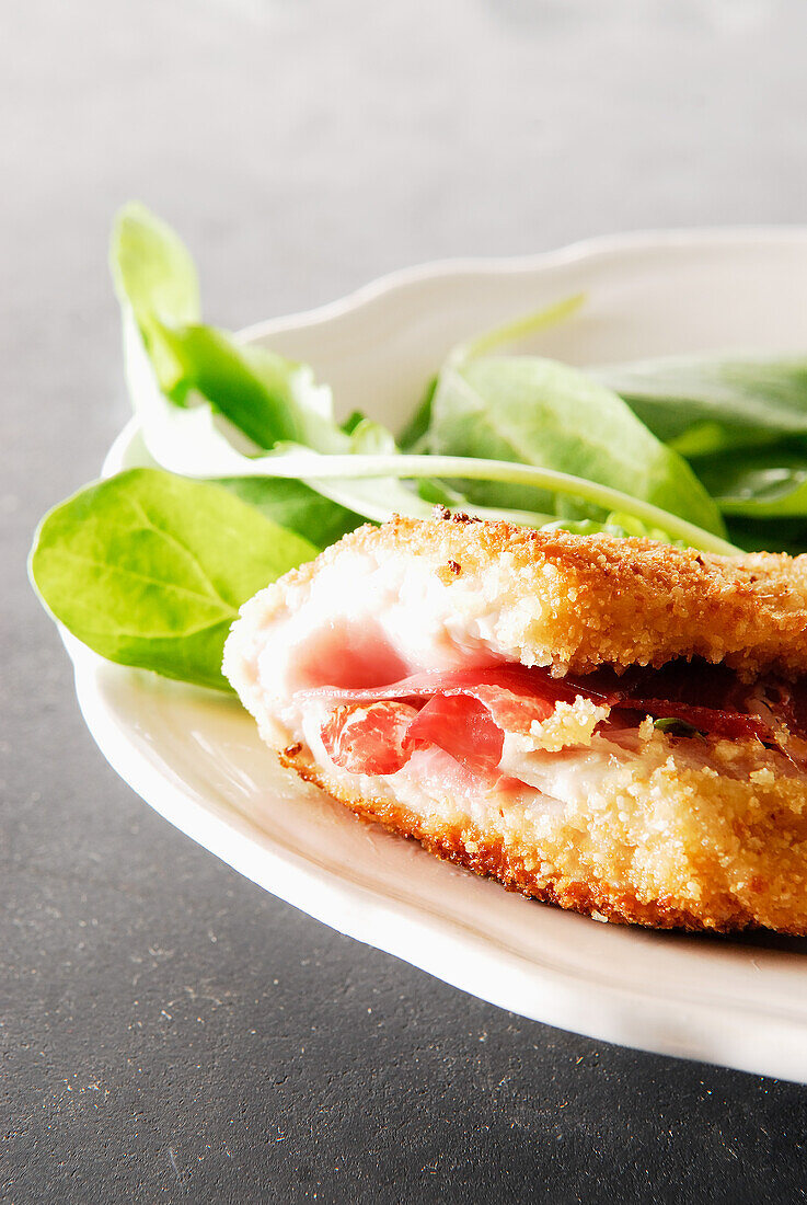 Breaded escalope with mozzarella and raw ham,spinach and rocket salad