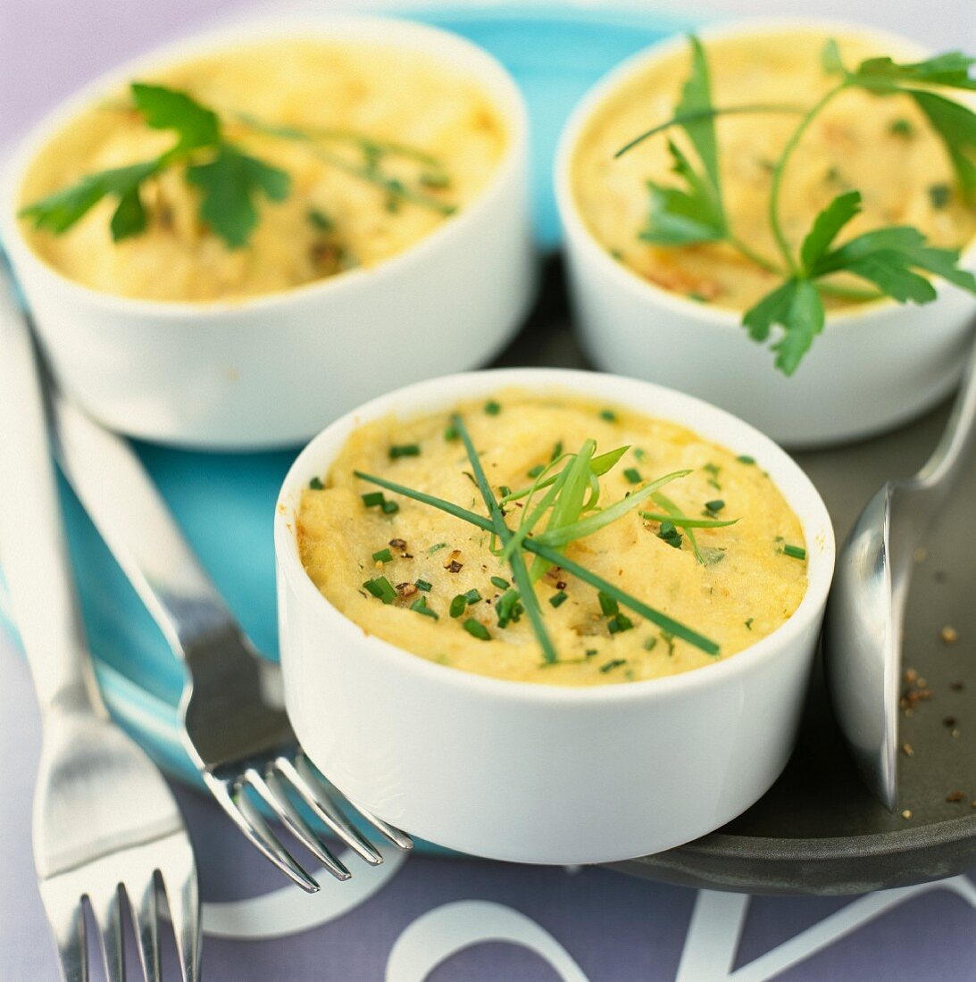 Dishes of mashed potato gratin with chives