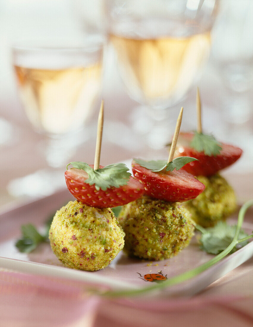 Fresh goat's cheese ball with herbs and strawberry bites