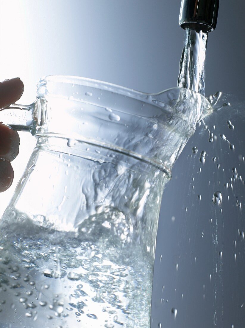 Glaskrug mit Leitungswasser füllen