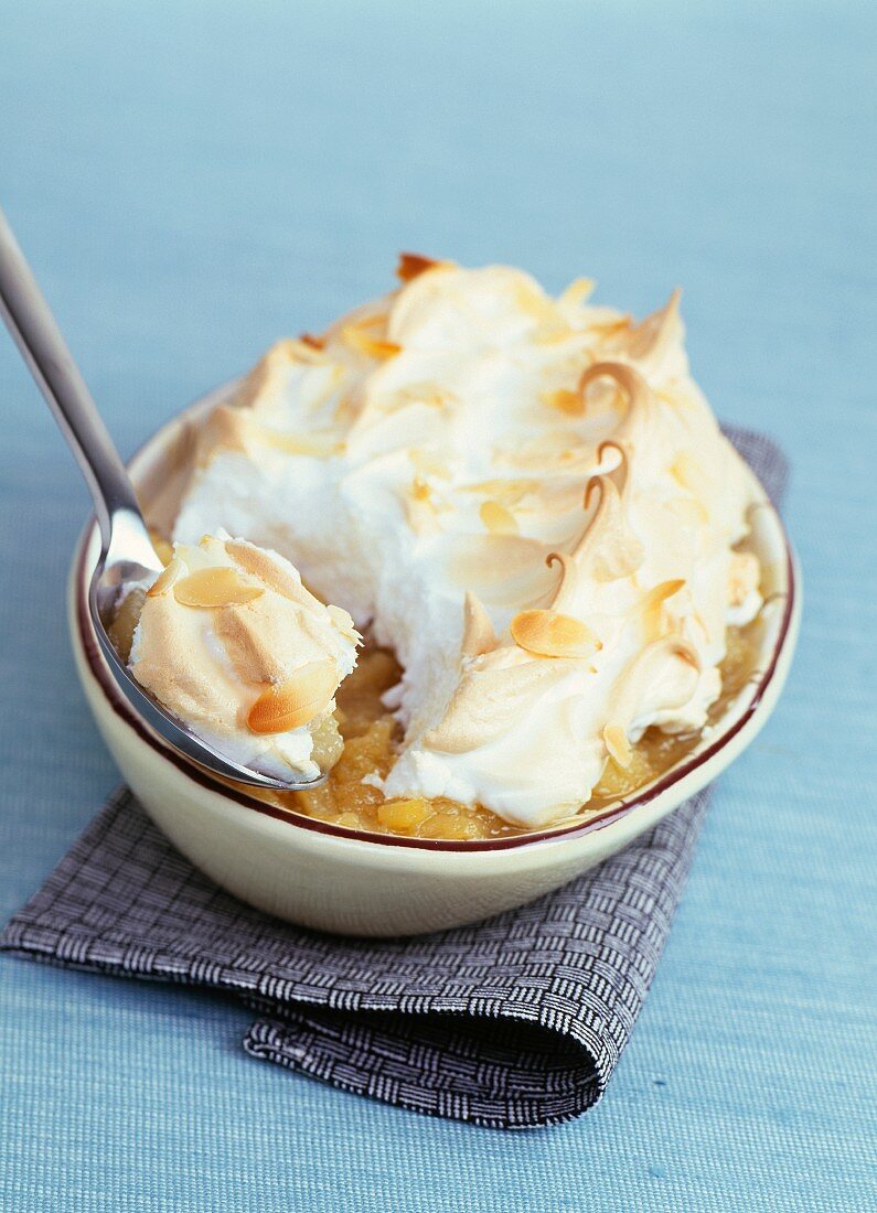 Stewed apple meringue pie with sliced almonds