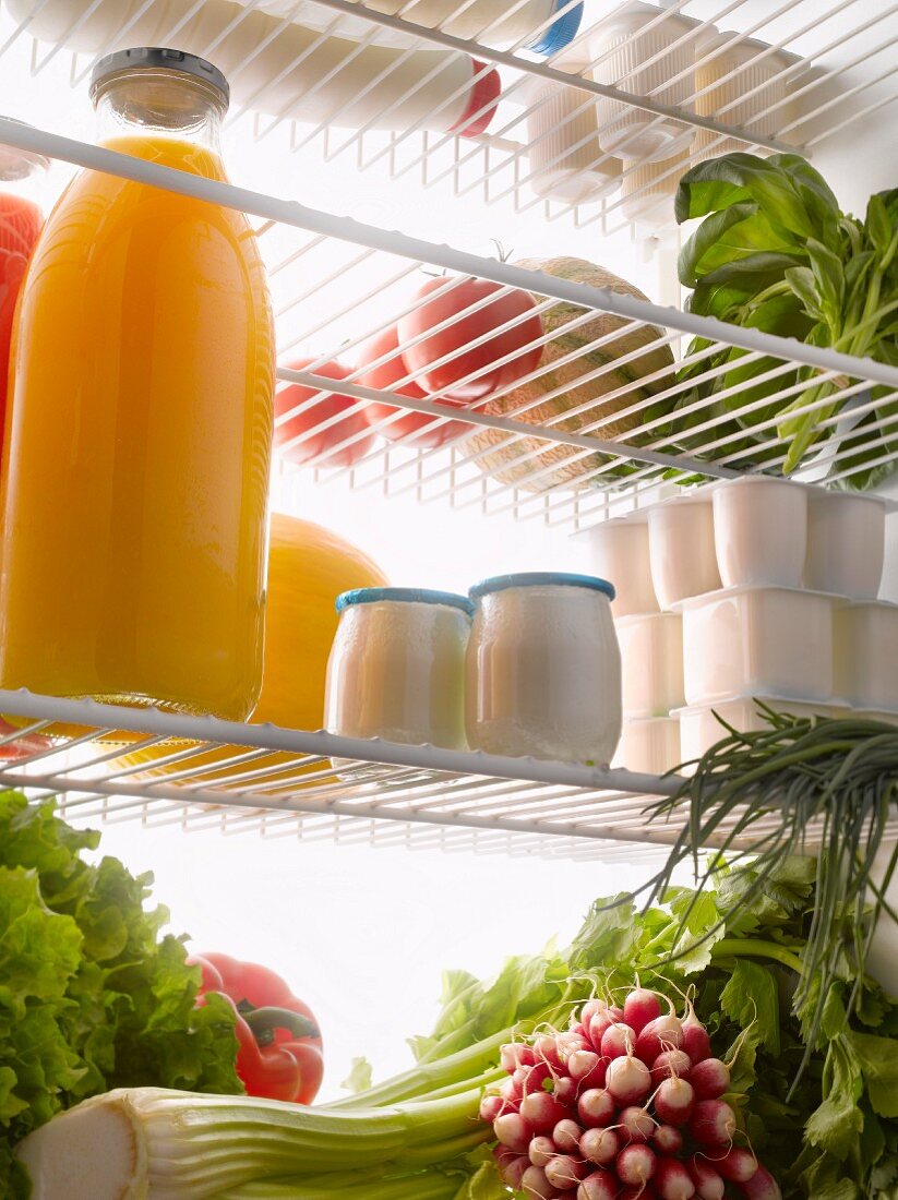 Blick in den Kühlschrank mit Obst, Gemüse, Milchprodukten und Saft
