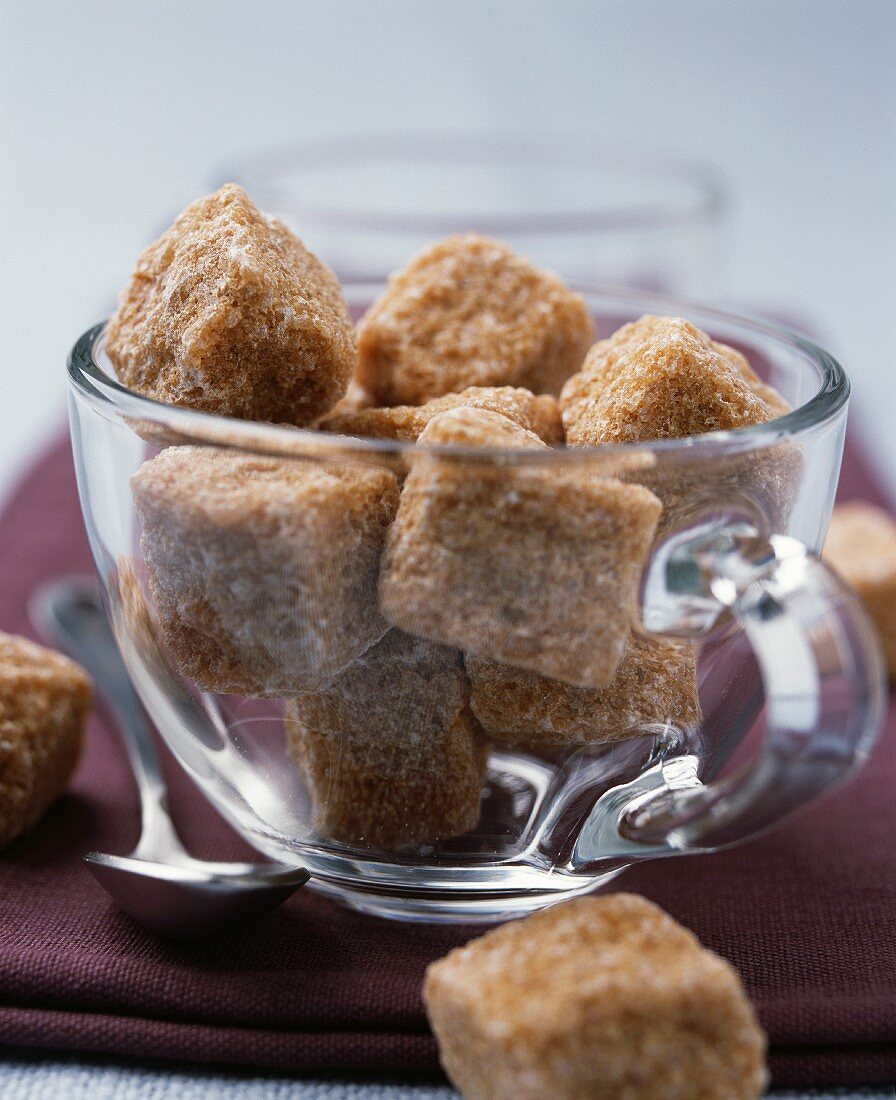 Lumps of brown sugar in a glass cup
