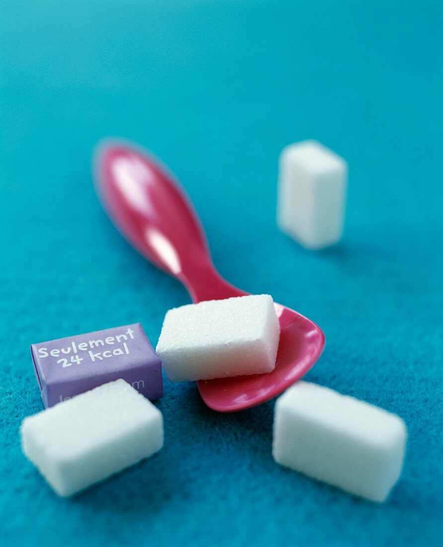 Sugar cubes and a pink plastic spoon
