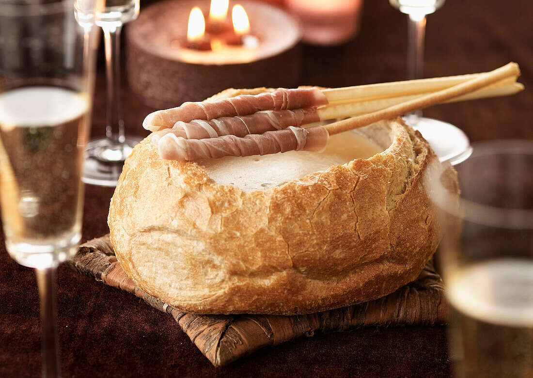 Champagne cheese Fondue served in a round loaf of bread