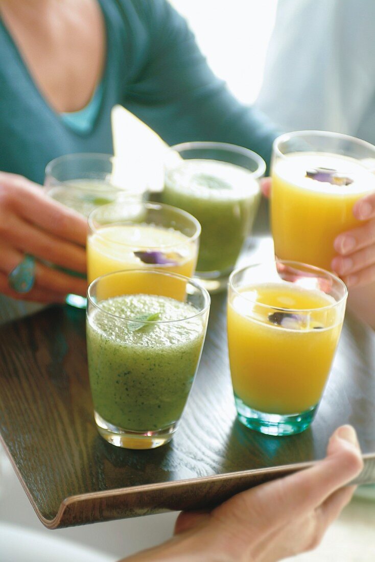 Melonen-Minz-Saft und Mangosaft in Gläsern auf Tablett