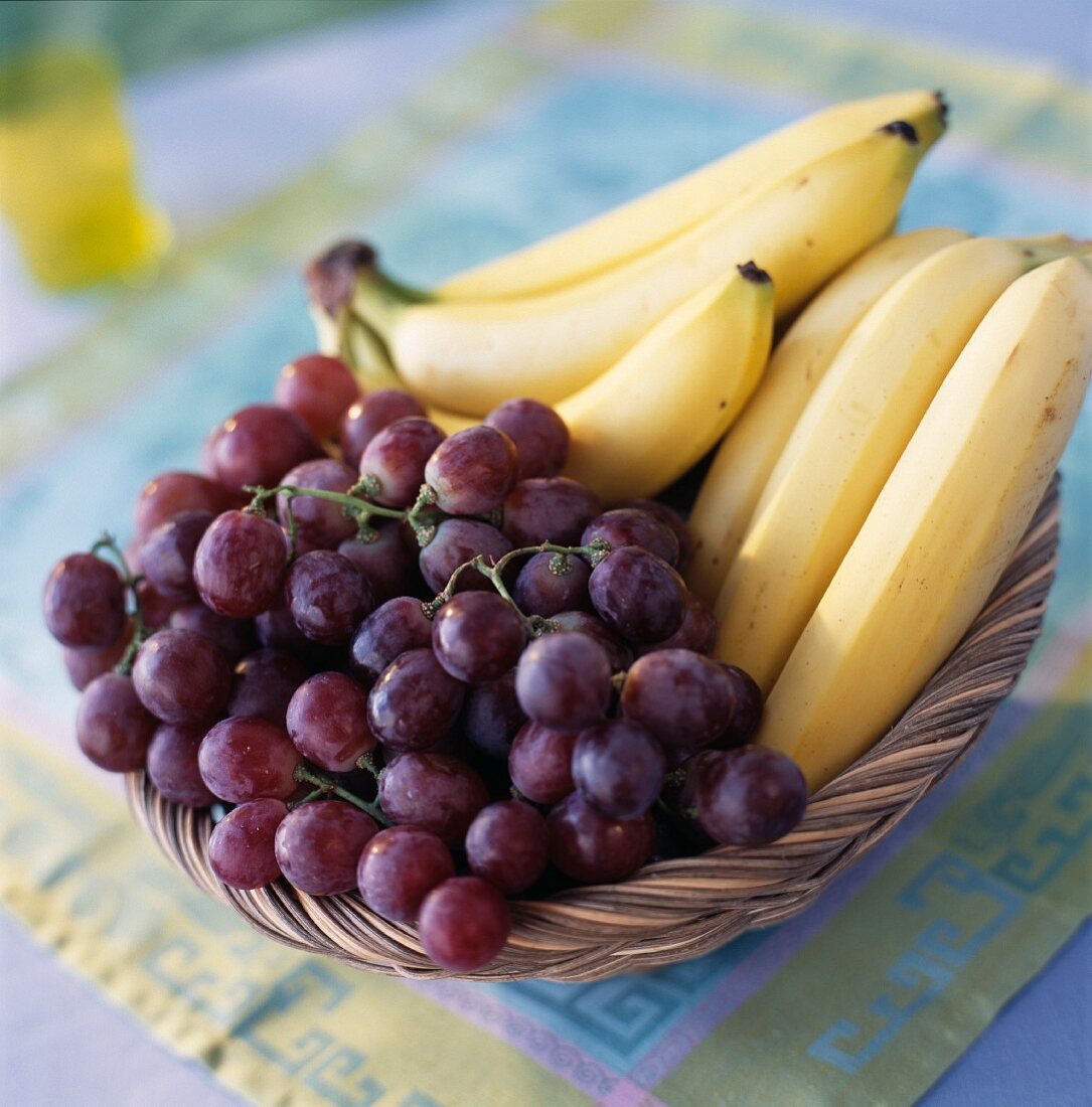 Schwarze Trauben und Bananen im Obstkorb