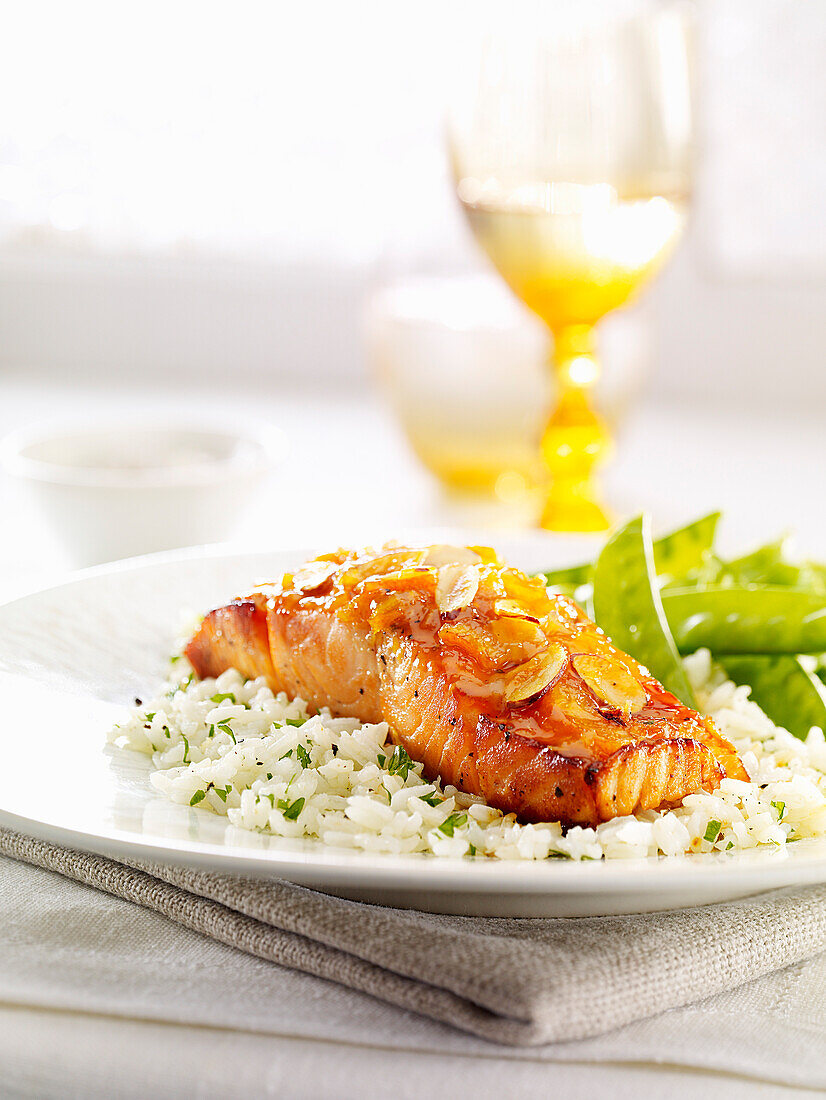 Grilled piece of salmon with almonds on a bed of rice