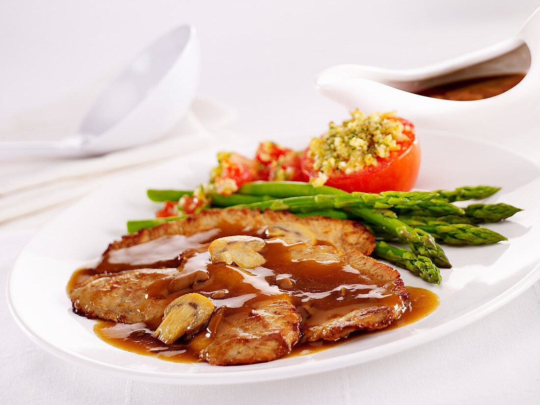 Pork shoulderblade bone with gravy ,green asparagus and provençal-style tomatoes
