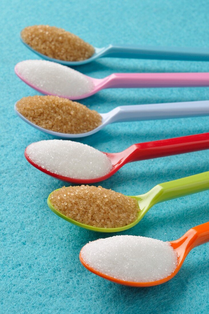 Plastic spoons with white and brown sugar