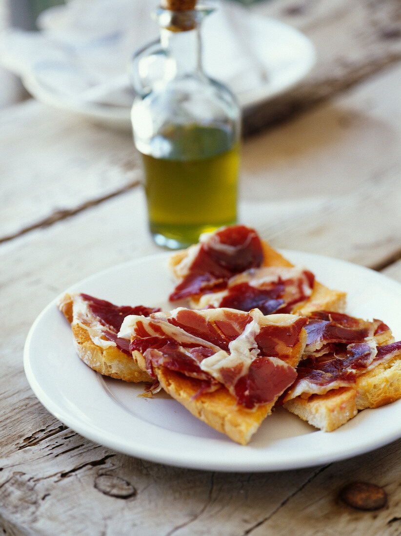Serrano-Schinken auf mit Tomaten eingeriebenem und mit Olivenöl beträufeltem geröstetem Brot