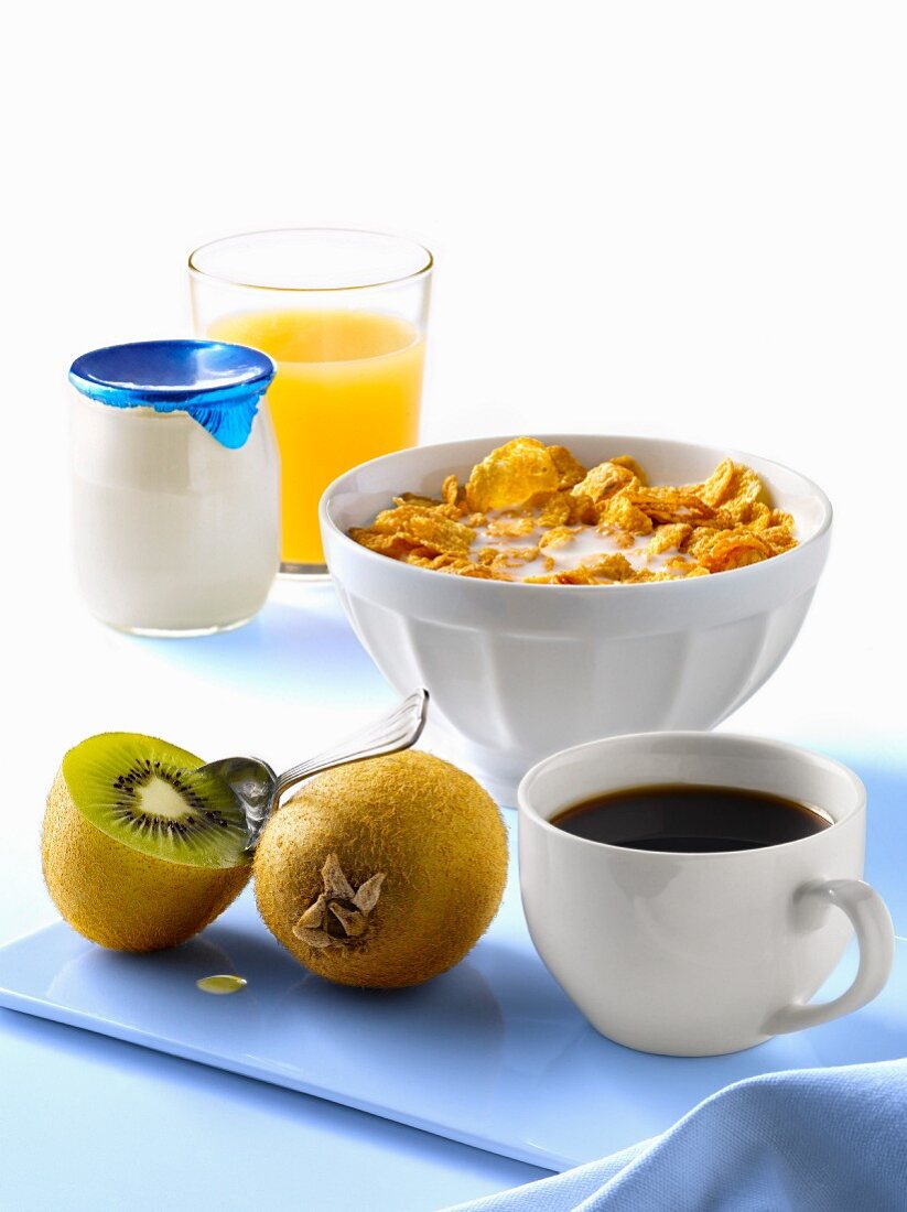 Frühstück mit Cornflakes, Kaffee, Kiwi, Joghurt und Saft