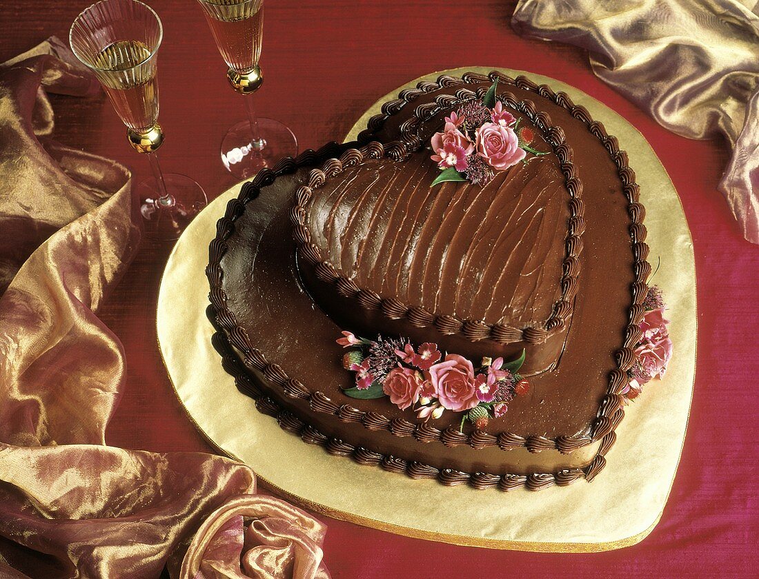 Zweistöckige herzförmige Schokoladentorte mit Blumendeko