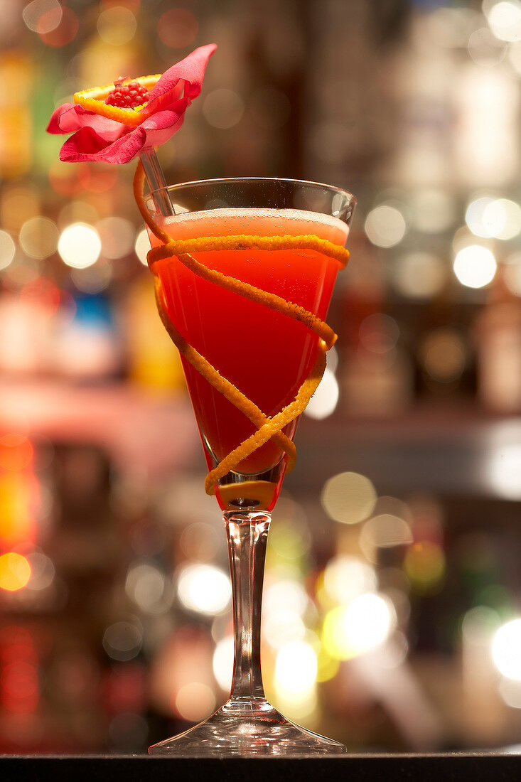 Orangencocktail mit Grenadine und Blüte