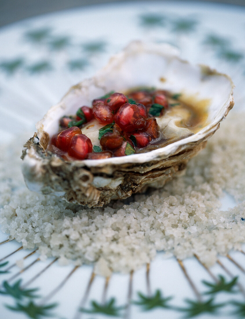 Hot oyster with hazelnut butter and pomegranate seeds and coriander