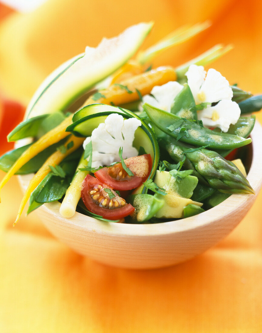 Frischer Gemüsesalat mit grünem Spargel, Zuckerschoten, Blumenkohl, Möhren und Tomaten