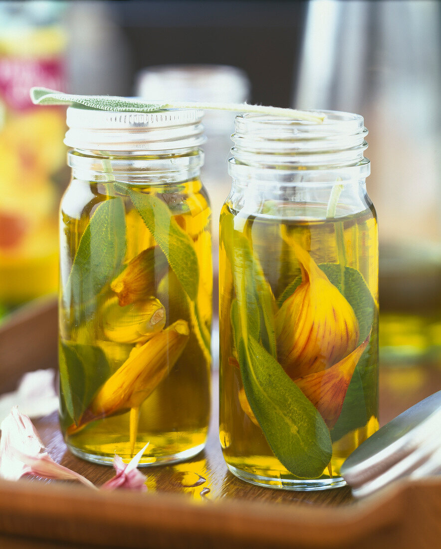 Olivenöl mit Knoblauch und Salbei in Gläsern