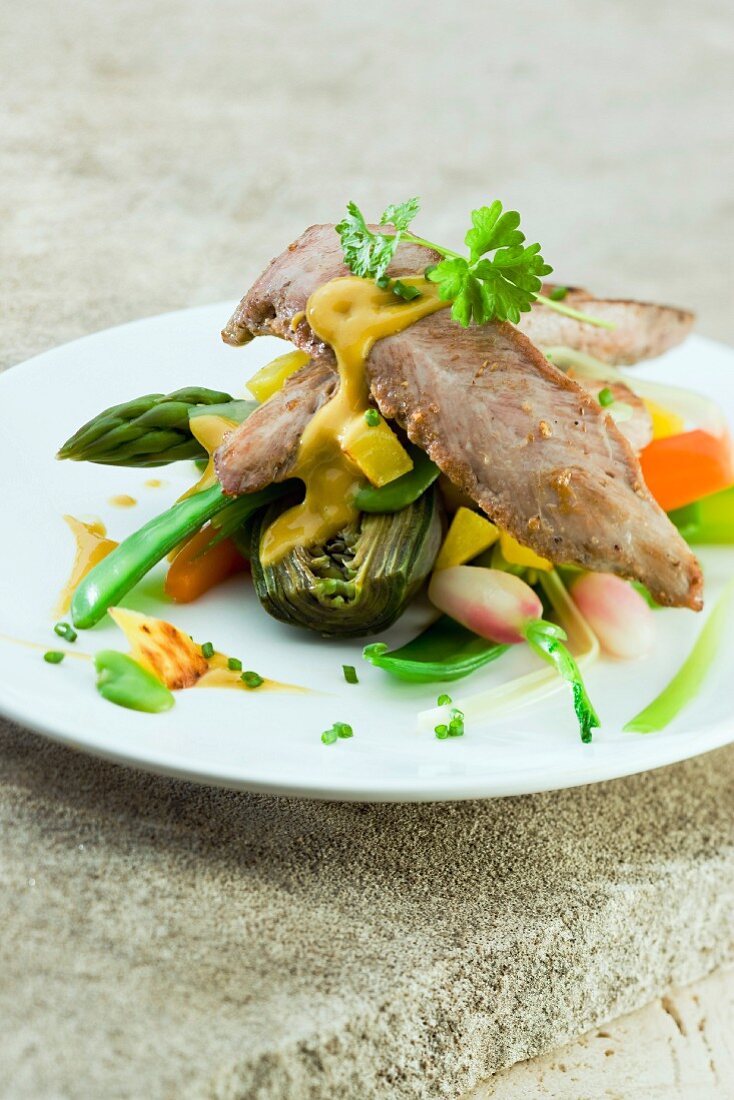 Sliced duck breast with spring vegetables