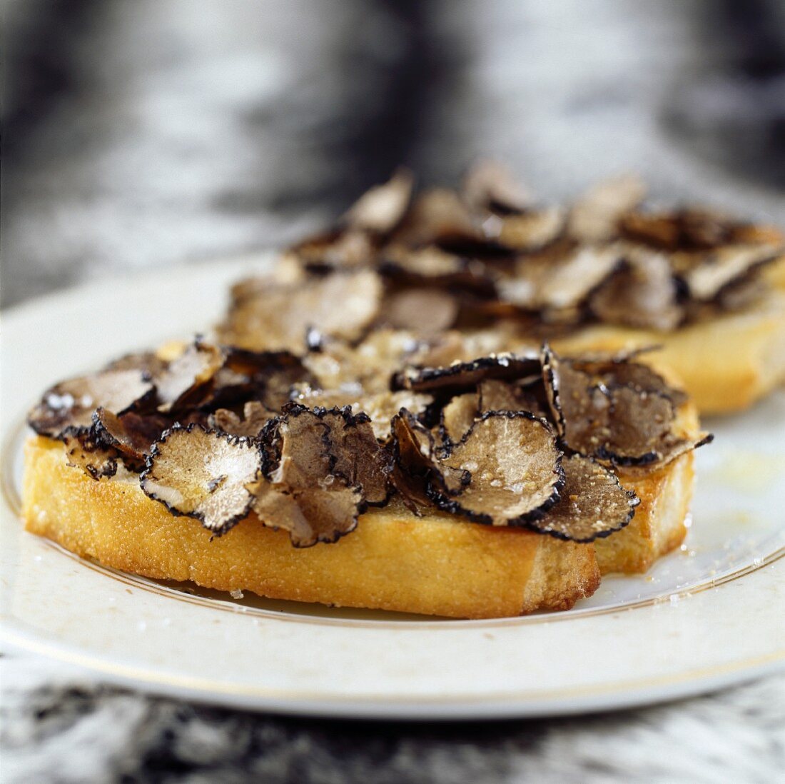 Thinly sliced truffles and Fleur de sel sea salt on a slice of bread