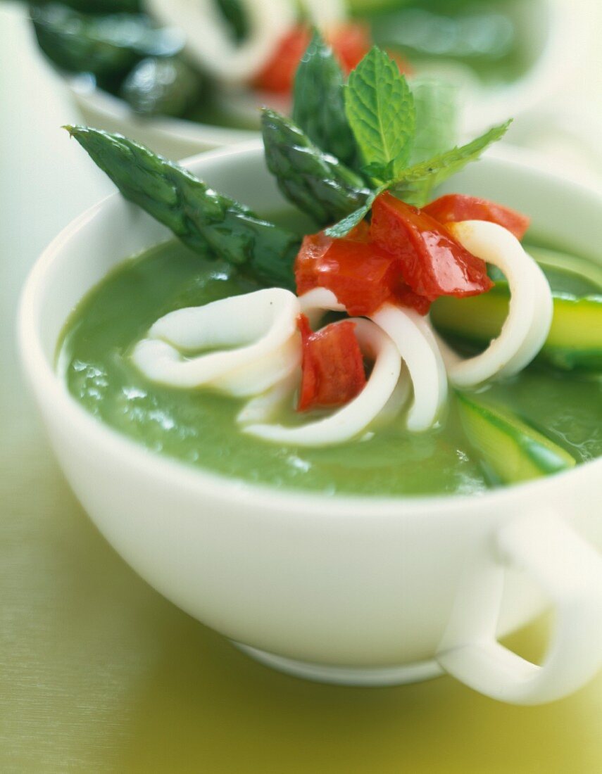 Cream of green asparagus soup with squid and red peppers