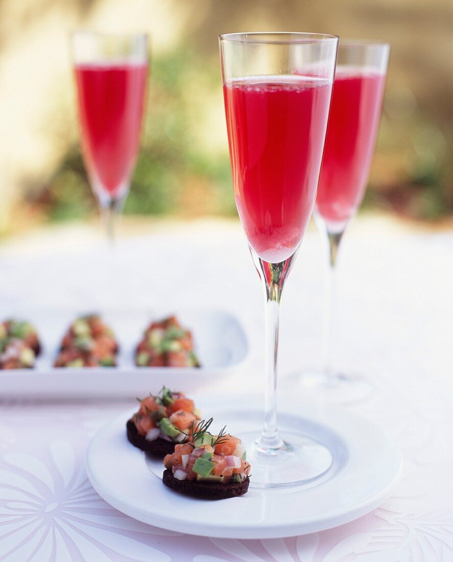 Raspberry cocktail, avocado and salmon on toasts