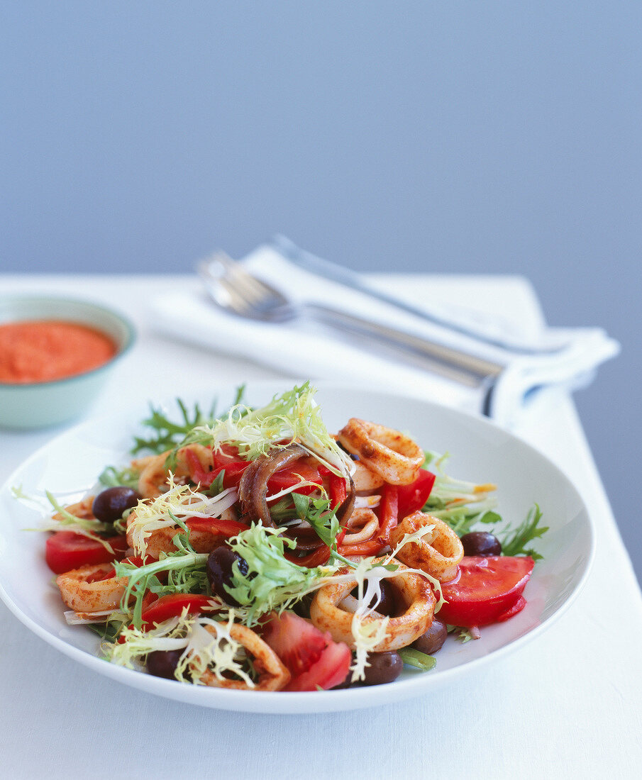 Salat mit Tomaten, Tintenfischringen und Sardellen