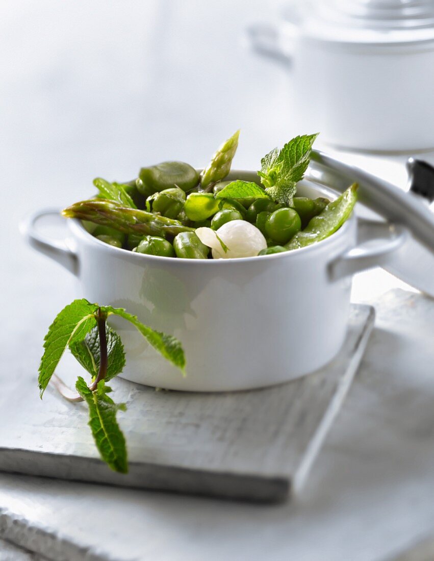 Casserole dish of spring vegetables with mint
