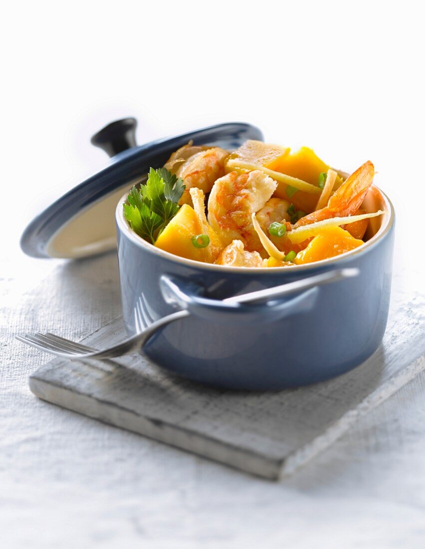 Casserole dish of gambas with mango and ginger