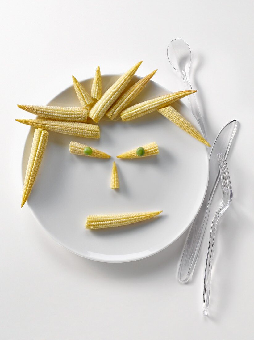 Plate of mini corn on the cobs in the shape of a face