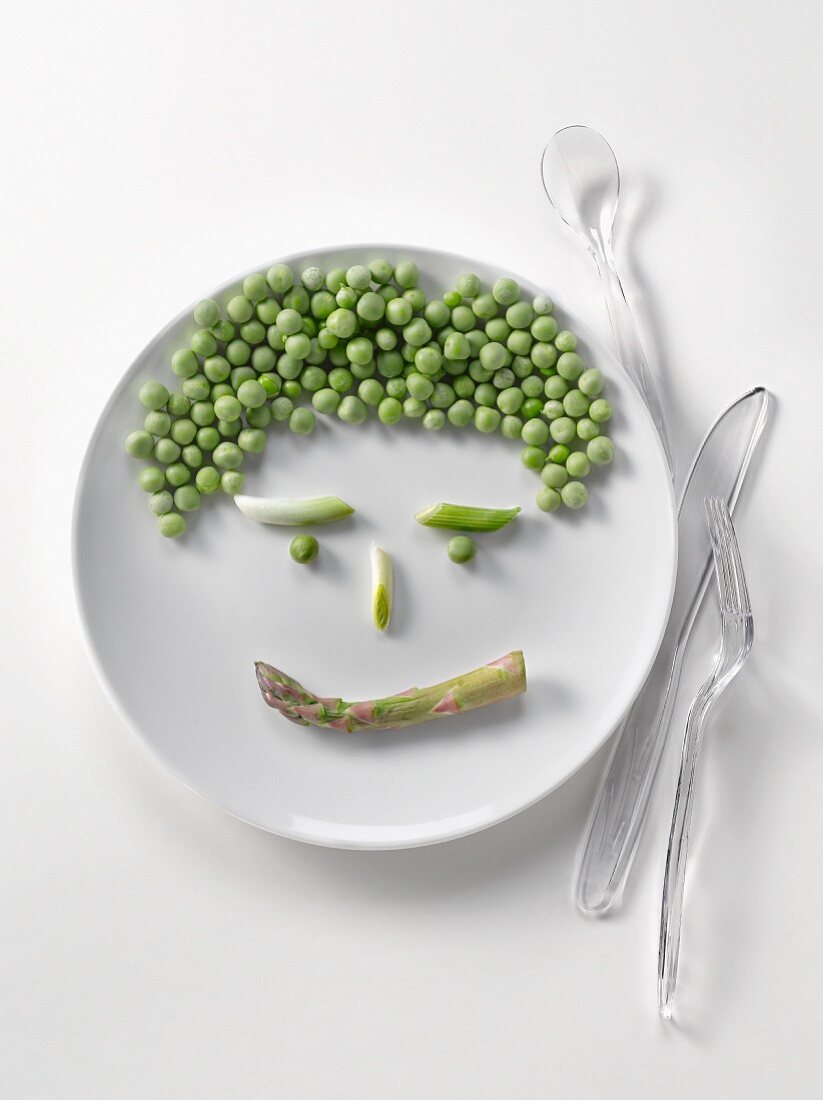 Plate of peas and asparagus in the shape of a face
