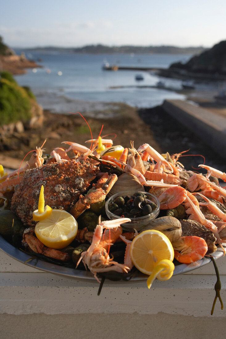 Meeresfrüchte-Platte in der Bretagne, Strand im Hintergrund