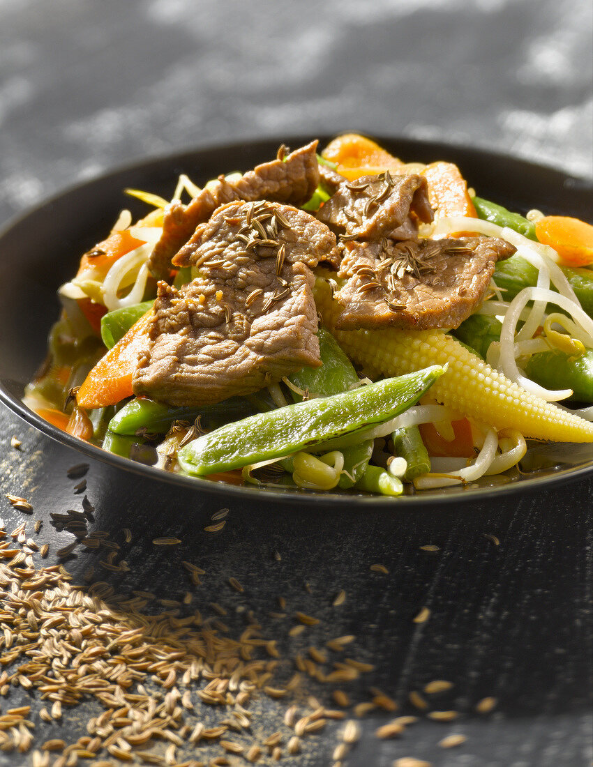 Beef and vegetables sauteed in a wok with cumin