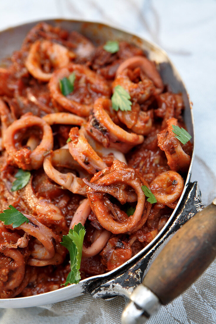 Cooking pot of squid in tomato sauce