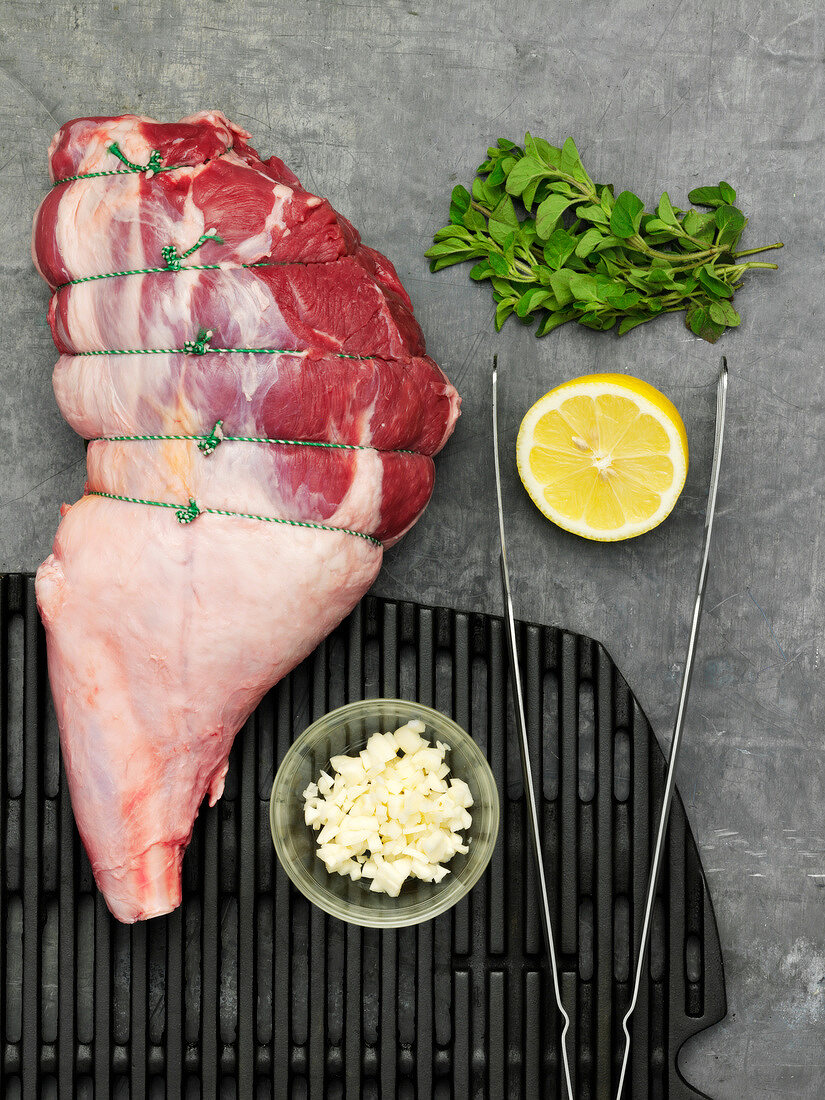 Raw stringed leg of lamb and ingredients