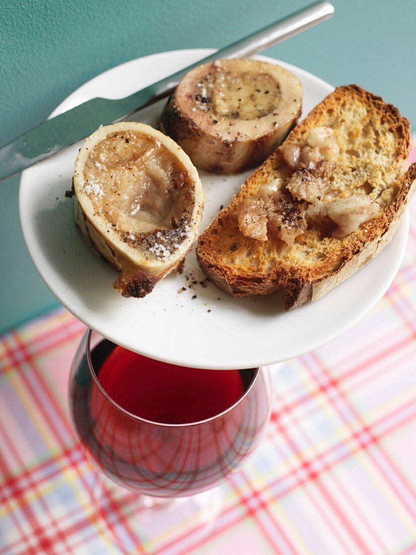 Röstbrot mit Markknochen und Glas Rotwein