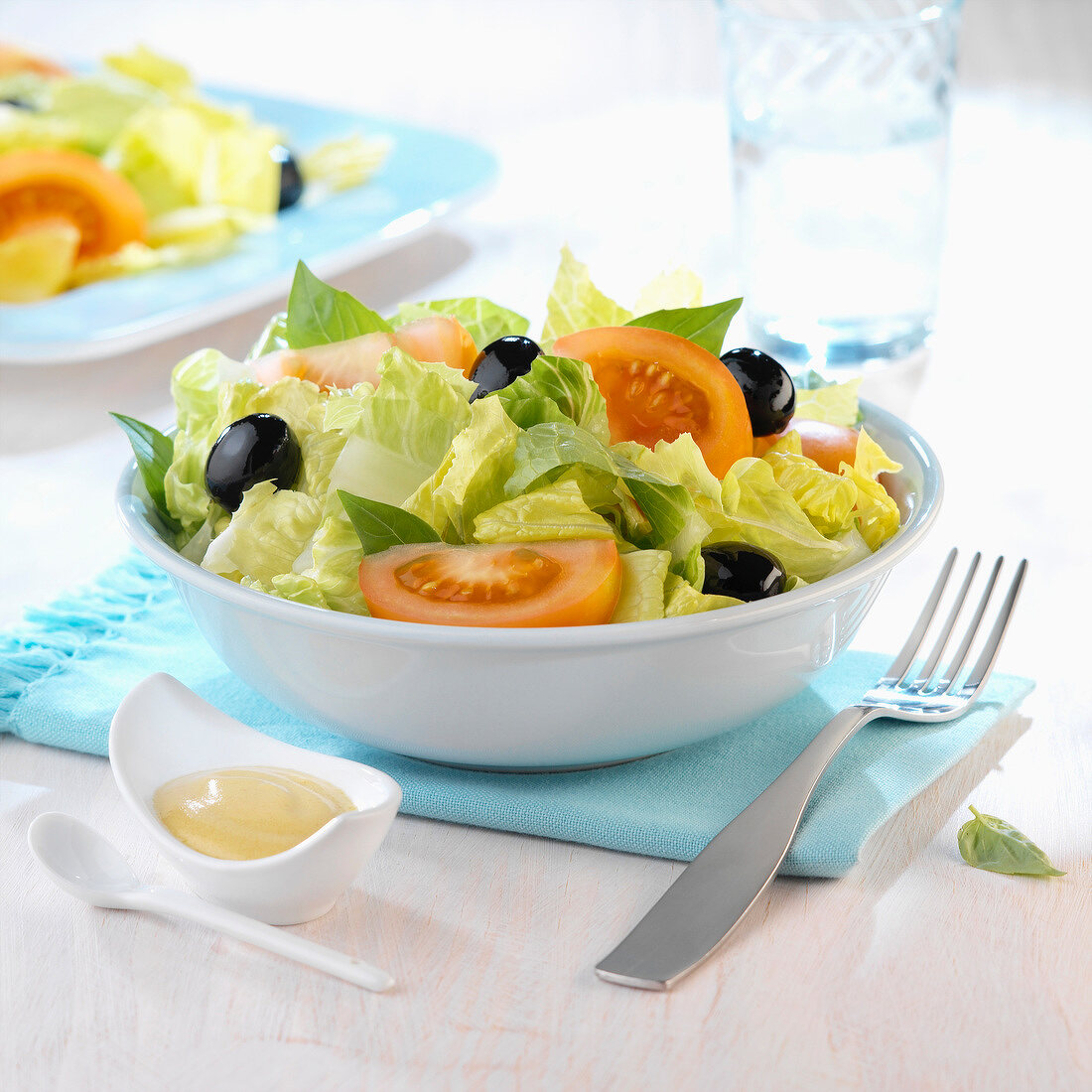 Blattsalat mit Tomaten und schwarzen Oliven