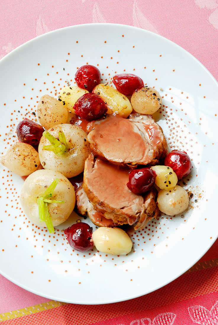 Sliced roast pork with cherries,turnips and grelot onions