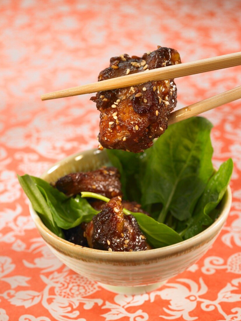 Sweet and sour pork with sesame seeds and spinach shoots